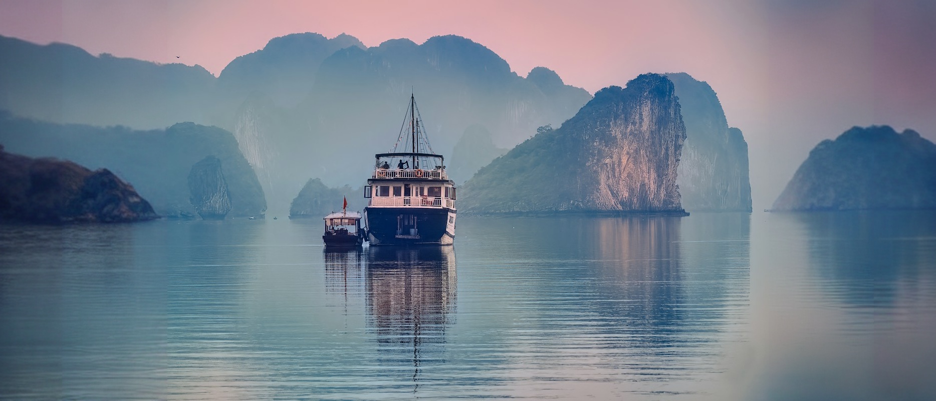 Ha Long Bay widened into a panorama: the painted sides continue the limestone islands, the mist and the water